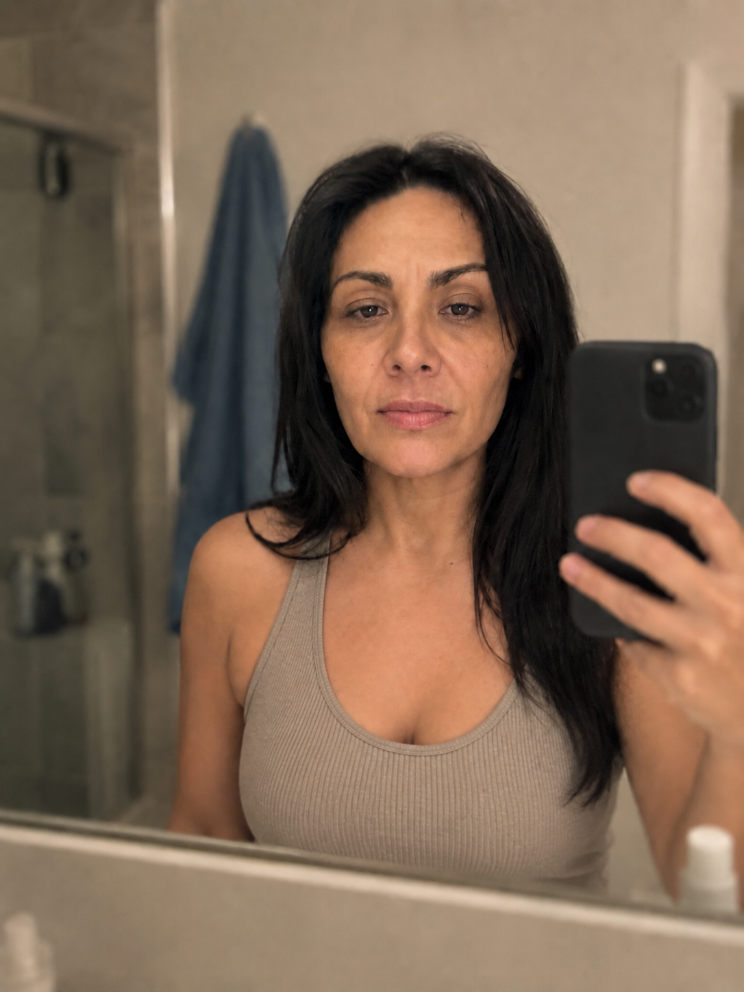 Looking at her face in the bathroom mirror